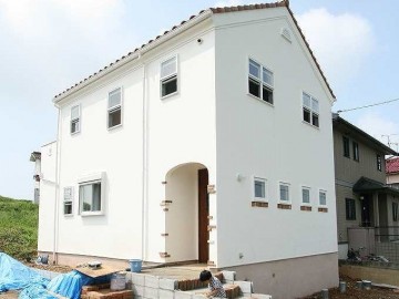 しっくいの壁、窓下にレンガをあしらった南欧風の外観